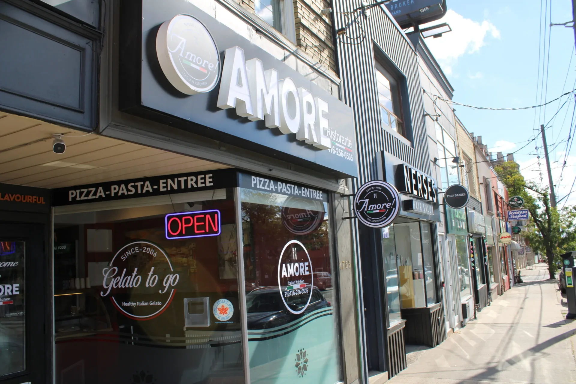 A store front of amore pizza in the city.